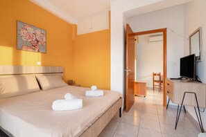 Une chambre d’hôtel équipée d’un lit, d’un bureau, d’une chaise et d’un téléviseur.