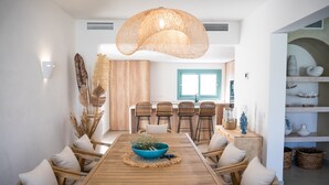 Un espace repas comprenant une table en bois, des chaises et un luminaire suspendu.