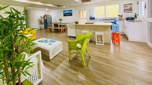 A spacious kitchen with a central island, wooden flooring, and a bright, well-lit environment.
