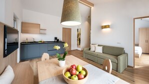 Un espacio de estar moderno con cocina, comedor y sofá.