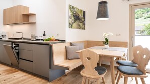 Een moderne keuken met een inbouw eiland, houten keukenkastjes en een eethoek met een tafel en stoelen.