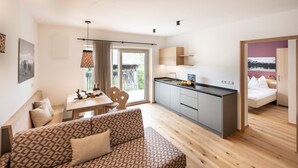 Un appartement moderne comprenant un canapé, une table à manger, un coin cuisine et une chambre avec un lit.