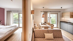 Une chambre d’hôtel moderne équipée d’un lit, d’un canapé, d’un coin repas et d’une cuisine.