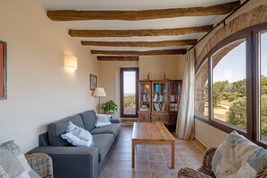 Uma sala de estar acolhedora com um sofá, uma mesa de centro de madeira e uma estante.