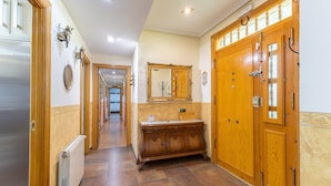 A hallway with a wooden door, a mirror, and a radiator. - Casa Rural Kalfonso - 6-Bed Finca in Toledo Province, Private Garden & AC (Mascaraque)