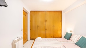 A bedroom with a bed, a wardrobe, and a radiator. - Apartment 'Cal Confianza' with Mountain View, Private Garden and Wi-Fi (Borredà)