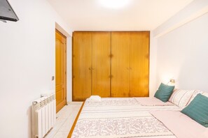 Une chambre à coucher avec un lit, une armoire et un radiateur.