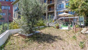 A courtyard with a tree, a small garden area, and a staircase leading to a balcony. - Apartment 'Cal Confianza' with Mountain View, Private Garden and Wi-Fi (Borredà)