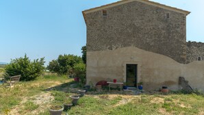 A rustic building with a sloped roof, a small door, and potted plants in front. - Studio Apartment 'L'Amaryflor' with Private Garden (Vaugines)