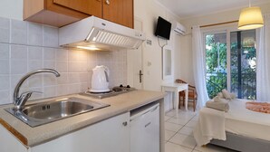 A modern kitchen with a built-in dishwasher, a coffee maker, and a window overlooking a balcony. - Studio Apartment 'S8' with Sea View, Wi-Fi and Air Conditioning (Lefkada)