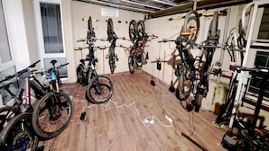 A room with a wooden floor, ceiling fans, and bicycles mounted on the wall. - 'Joyfül Accomodation Camera 1' with Wi-Fi and Air Conditioning (Finale Ligure)