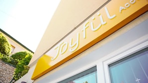 A building with a sign that reads 'Joyful Accommodations.' - 'Joyfül Accomodation Camera 1' with Wi-Fi and Air Conditioning (Finale Ligure)