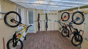A covered outdoor area with bicycles mounted on racks, a door, and a tiled floor. - 'Joyfül Accomodation Camera 1' with Wi-Fi and Air Conditioning (Finale Ligure)