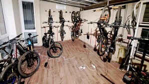 Una habitación con suelo de madera, ventiladores de techo y bicicletas colgadas en la pared.