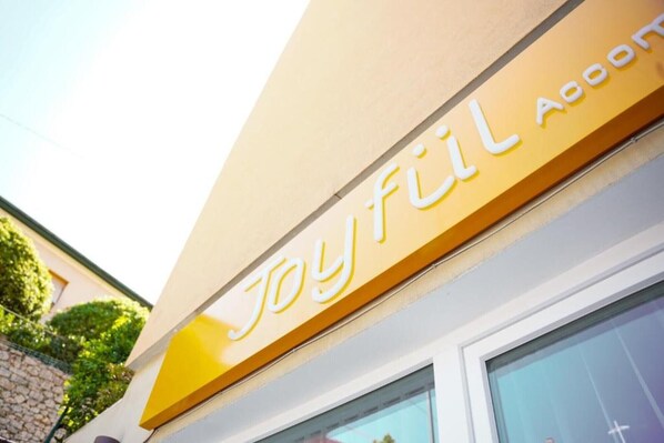 A building with a sign that reads 'Joyful Accommodations.'