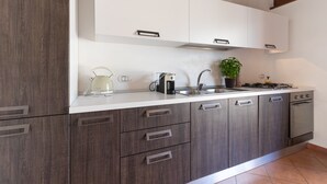 Una cucina moderna con pensili bianchi, elettrodomestici in acciaio inossidabile e forno integrato.