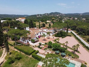 Una villa con piscina, rodeada de vegetación exuberante y un paisaje montañoso.