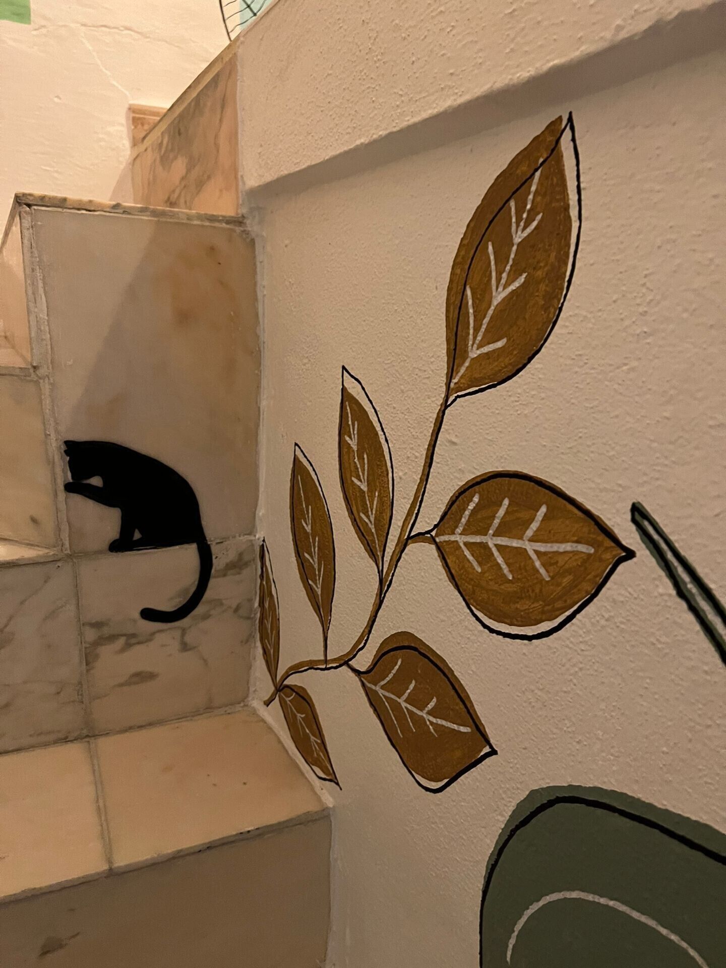 Una escalera con un diseño de hojas pintado en la pared.