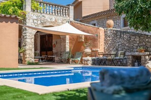 A pool area with a stone wall, outdoor seating, and a covered patio. - Holiday Home 'Ca'n Blanch' with Private Pool, Private Terrace and Wi-Fi (Biniamar)