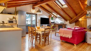 Een ruime loft met keuken, eethoek en woonkamer met een rode bank.