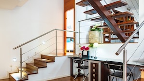 A modern interior with a wooden staircase, a desk with a chair, and a bookshelf. - Entregredos: Rural House in Sierra de Gredos with Pool and Jacuzzi (Guisando)