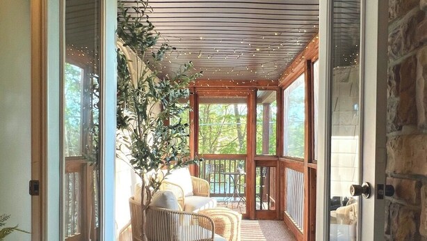 Une pièce chaleureuse avec un plafond en bois, un coin salon confortable et une grande fenêtre.