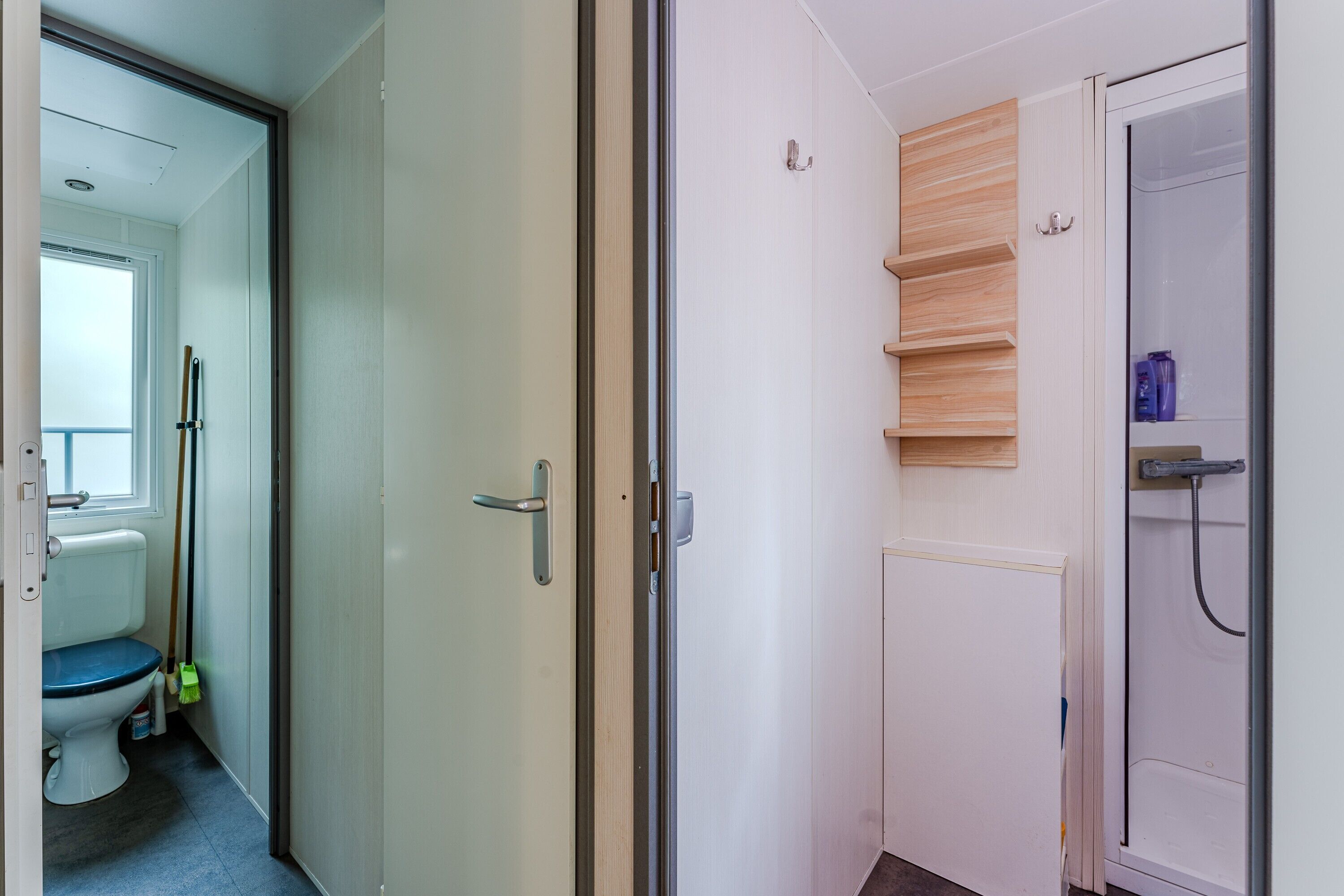 A bathroom with a toilet, shower, and storage shelves.