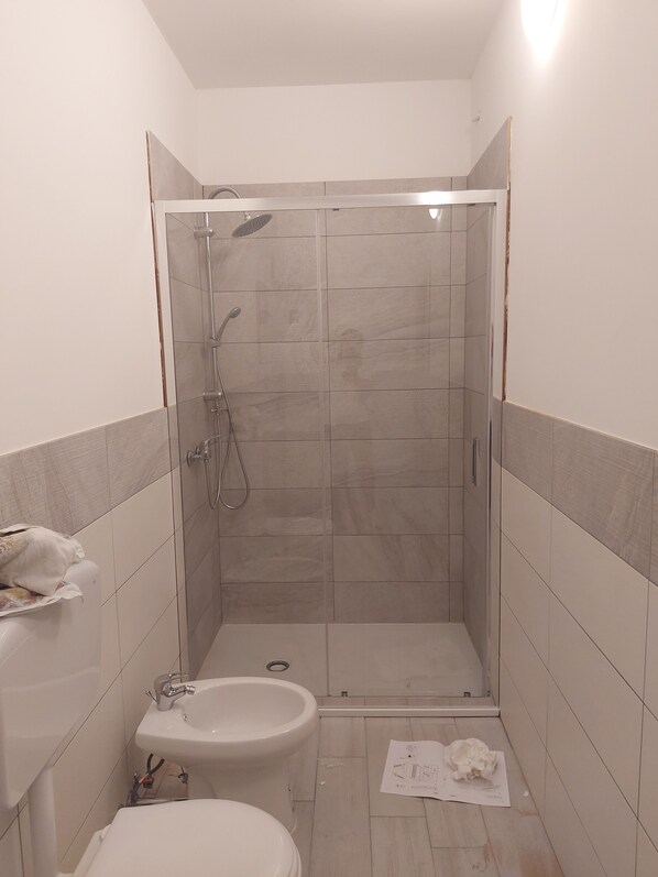 A small, tiled bathroom with a shower, toilet, and sink. - A casa di Adua (Cupello)