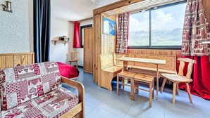 Una habitación acogedora con un banco de madera, una mesita pequeña y un sofá estampado.