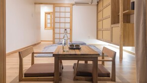 A wooden dining table with four chairs, a pitcher, and a tray with plates. - Hajime Homestay (Hue)