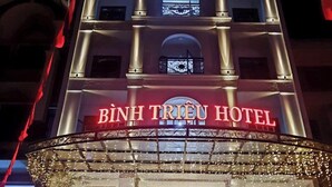 A Binh Triet Hotel külső megjelenése: feltűnő tábla, nagy bejárat és díszes világítás jellemzi.