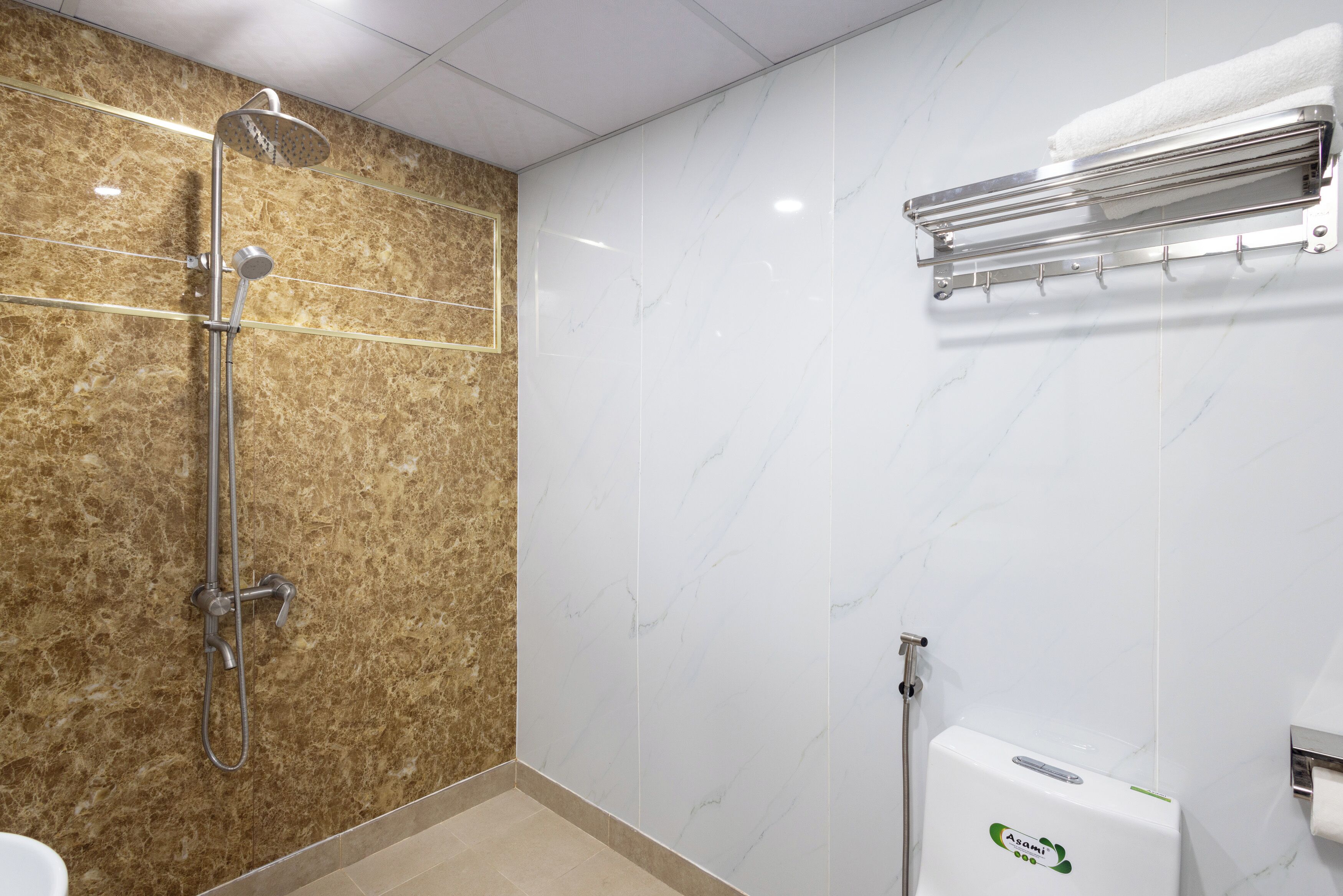 A bathroom with a shower, a towel rack, and a toilet.