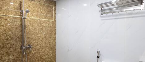 A bathroom with a shower, a towel rack, and a toilet.