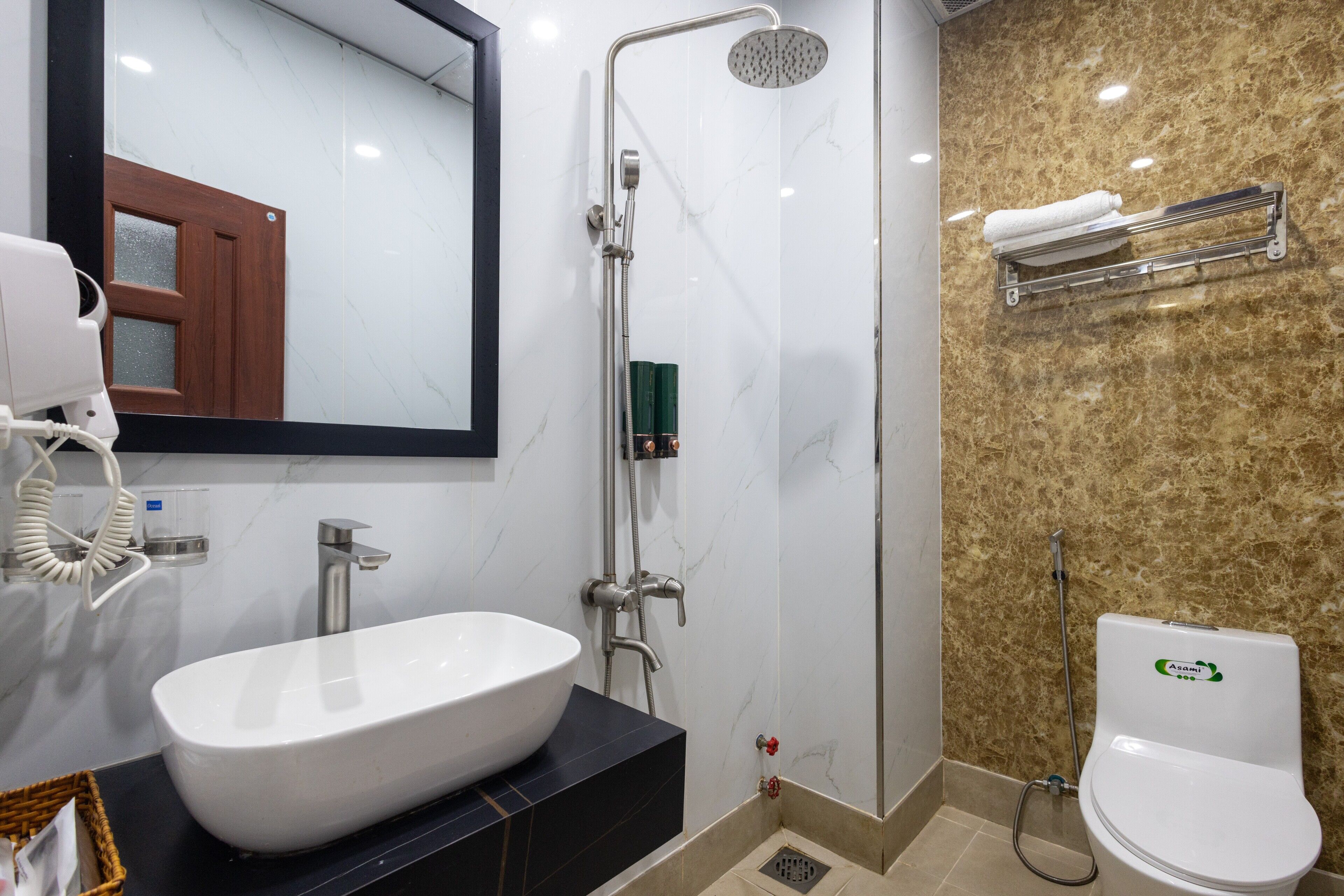 A bathroom with a white sink, a shower, and a toilet.