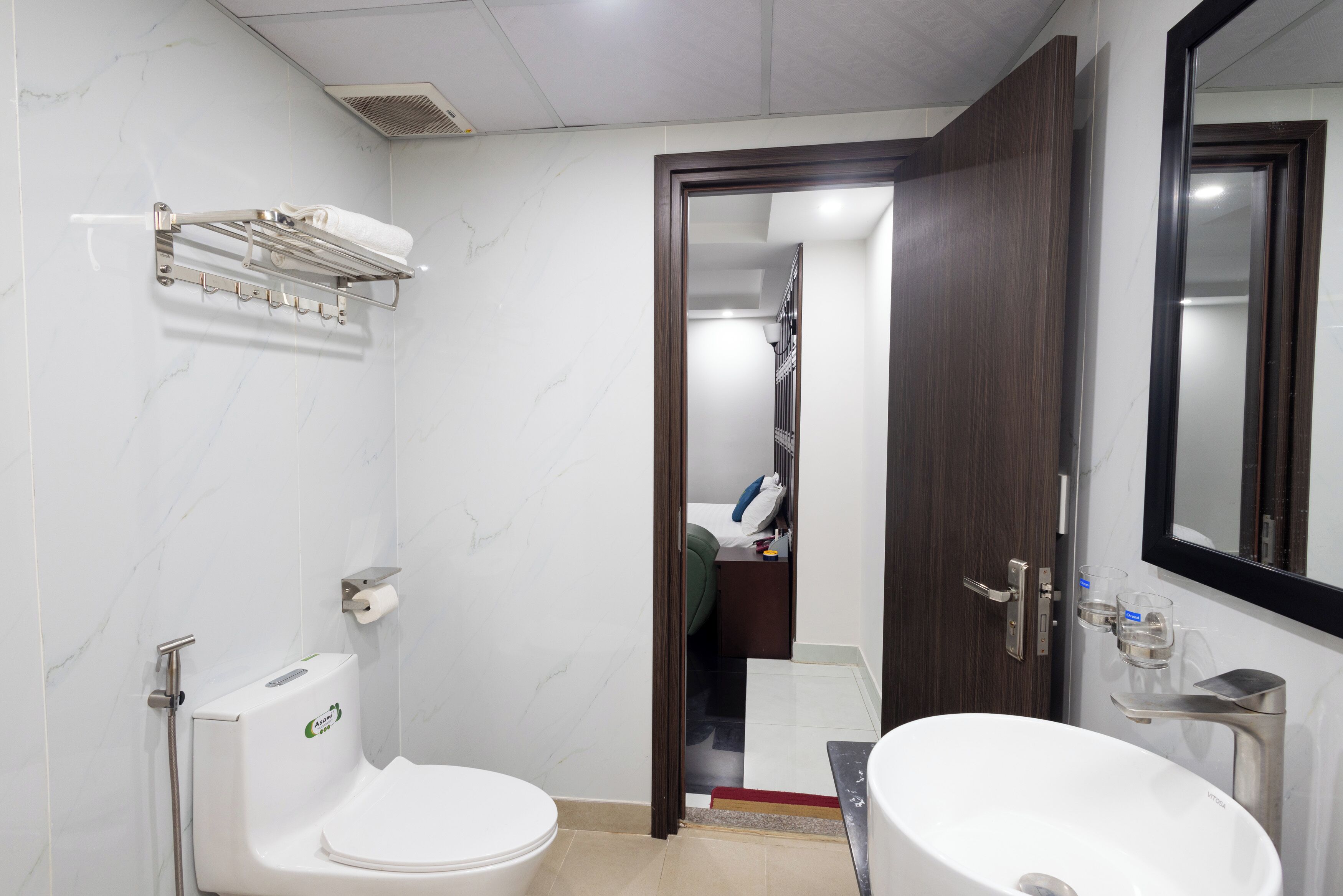 Et moderne badeværelse med toilet, vask og håndklædestang.