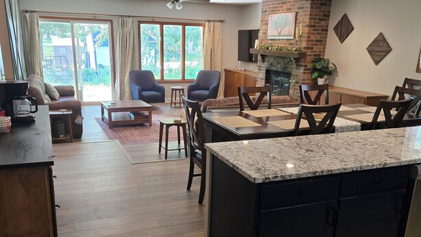Amplia sala de estar con isla de cocina, mesa de comedor y asientos.