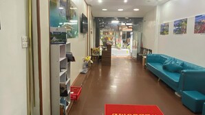A hotel lobby with a red carpet, a scale, a blue sofa, and a storefront named 'flora'. - Impressive Boutique Hotel (Hanoi)