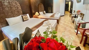 A hotel room with two beds, a dining area, and a TV mounted on the wall. - Impressive Boutique Hotel (Hanoi)