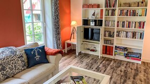 Un salon comprenant un canapé, une table basse, une bibliothèque et un meuble pour la télévision.