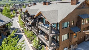 A multi-story hotel with balconies, a ski slope in the background, and a mountainous landscape. - Walk to Skiing, Exceptional Juniper Landing 5 BR, Private Hot Tub, Golf Course Views, Outdoor Pool (Park City)