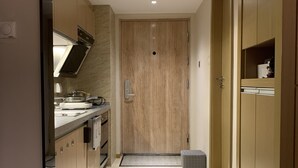 Eine moderne Küche mit Holzausstattung, einem Einbauofen und einer Arbeitsplatte mit Spüle.