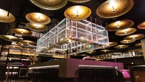 Uma área de bar com várias luminárias pendentes e um balcão.