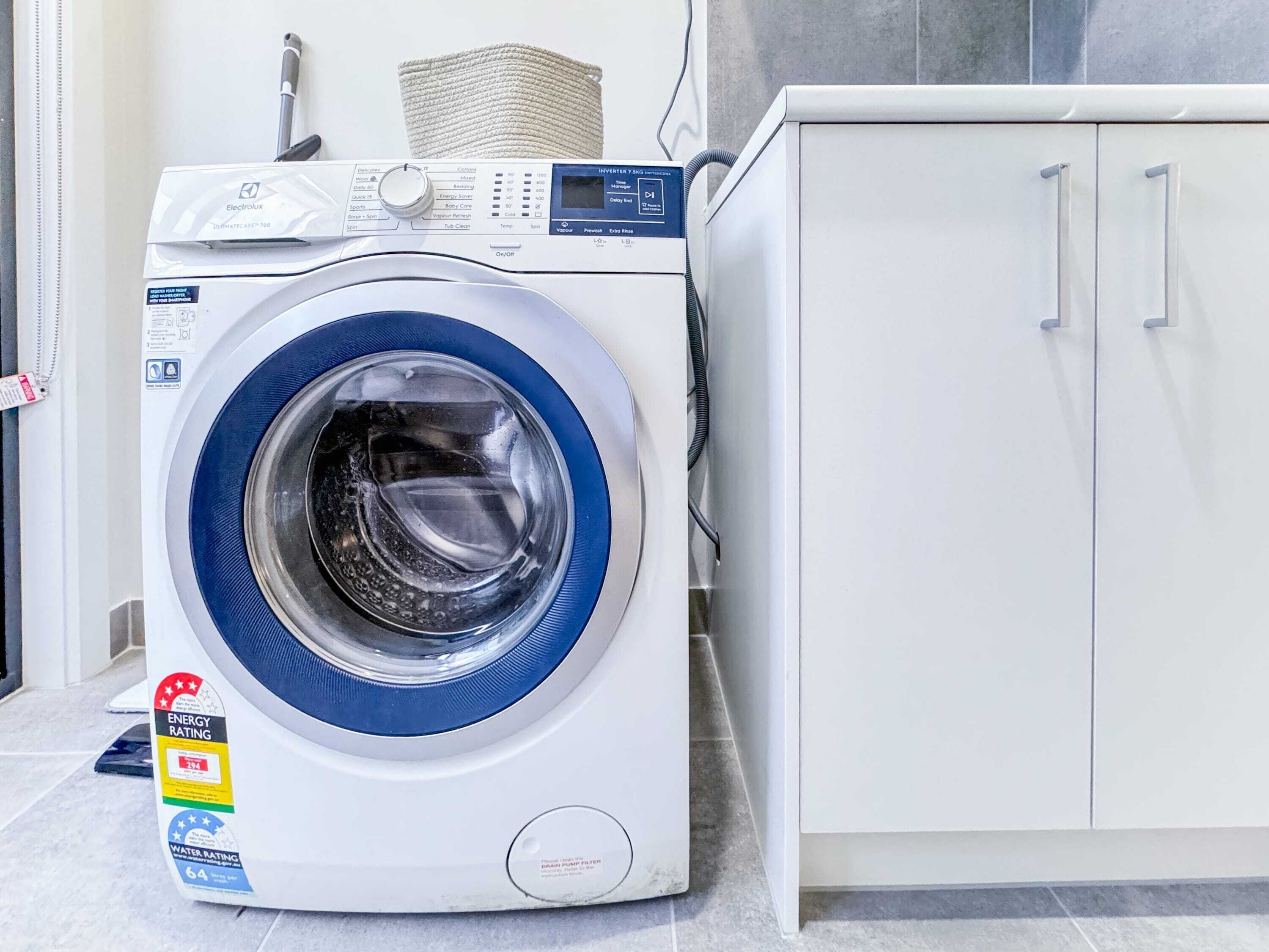 Eine Waschmaschine mit Frontlader, digitaler Anzeige, Kennzeichnungen für Energieeffizienz und Wasserverbrauch sowie einer Bedienkonsole.
