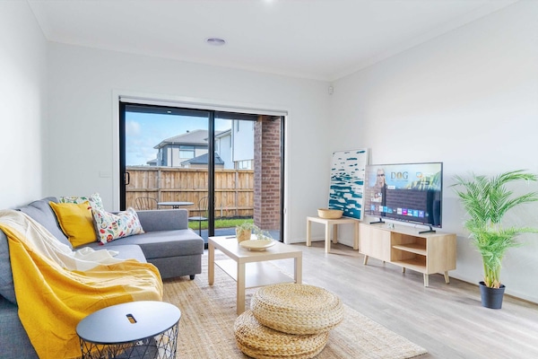 Modern living room with cozy seating, stylish decor, and large glass doors opening to a private yard.