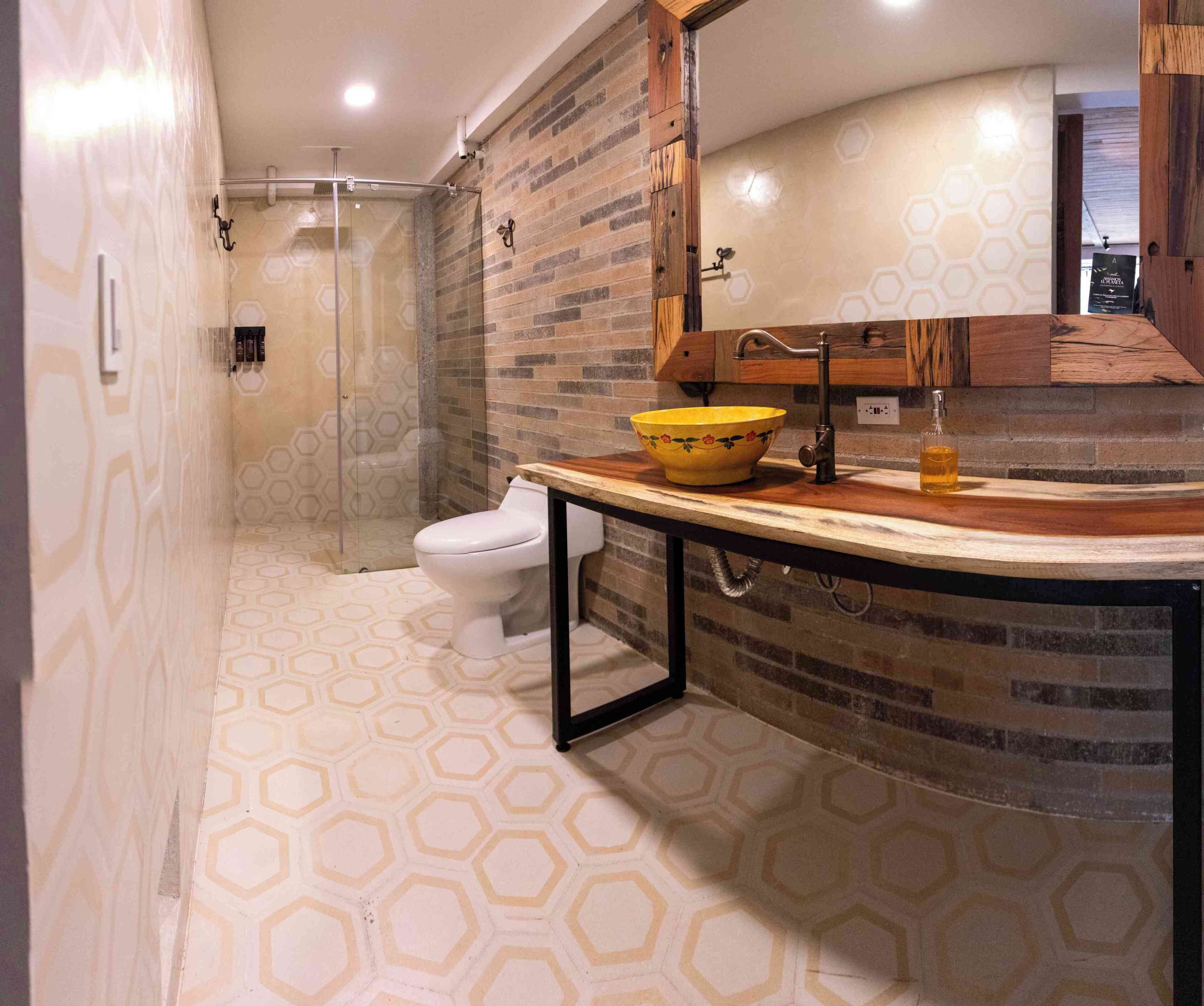 A bathroom with a shower, toilet, and a sink with a wooden countertop.