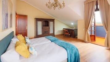 A bedroom with a bed, a chandelier, a wardrobe, and a desk.