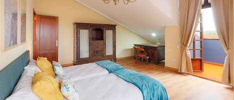 A bedroom with a bed, a chandelier, a wardrobe, and a desk.