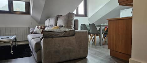 Un salon moderne comprenant un canapé, une table à manger et un coin cuisine.