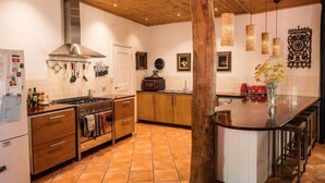 Una cucina con mobili in legno, un fornello e lampade a sospensione.