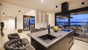 A modern kitchen with a central island, built-in appliances, and a view of the outdoors.